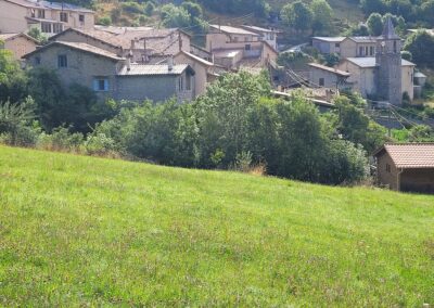 Le clocher et les toits de Chavailles vus depuis une prairie.